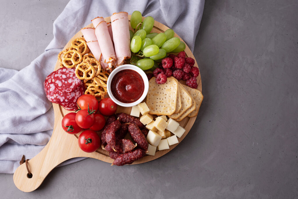 Charcuterie with grapes, tomatos, meat, and cheese